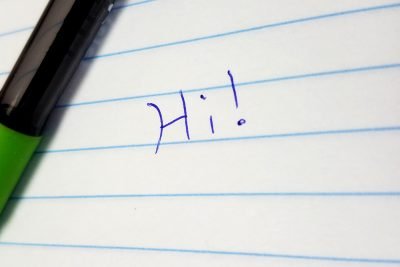 Handwritten "Hi" on a sheet of paper