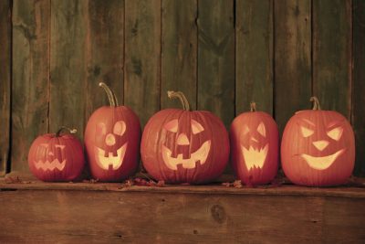 Five happy-faced Jack-o-lanterns in a row
